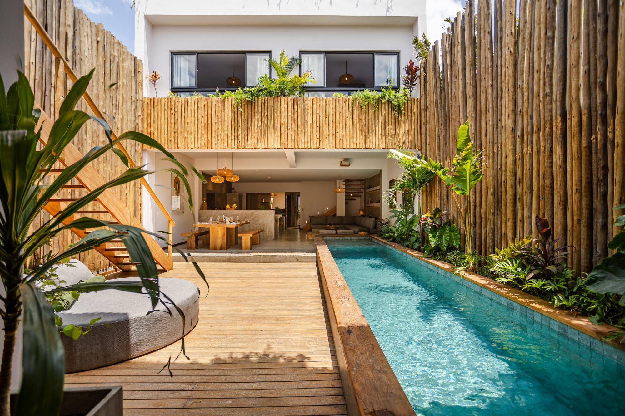 Le patio en plein jour, la piscine longe la façade de bambou